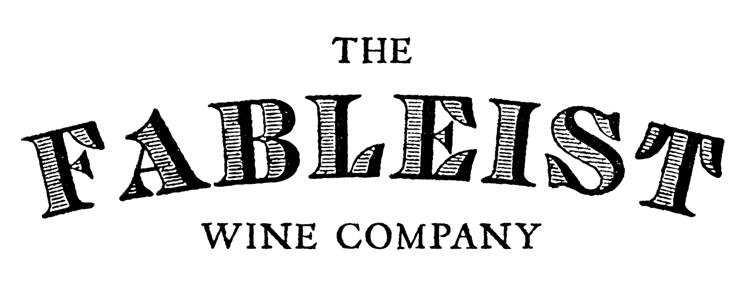 Logo for The Fableists Wine Company with stylized curved lettering on a black background.